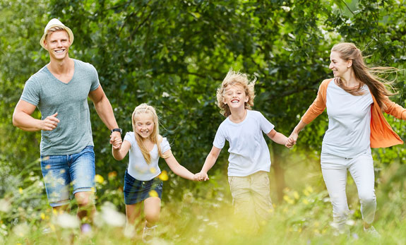 eine Familie läuft durch eine Blumenwiese